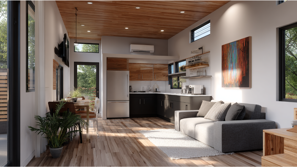 Modern ADU living space with a wood-accented ceiling, compact kitchen, wall-mounted TV, cozy gray couch, and floor-to-ceiling windows bringing in natural light.