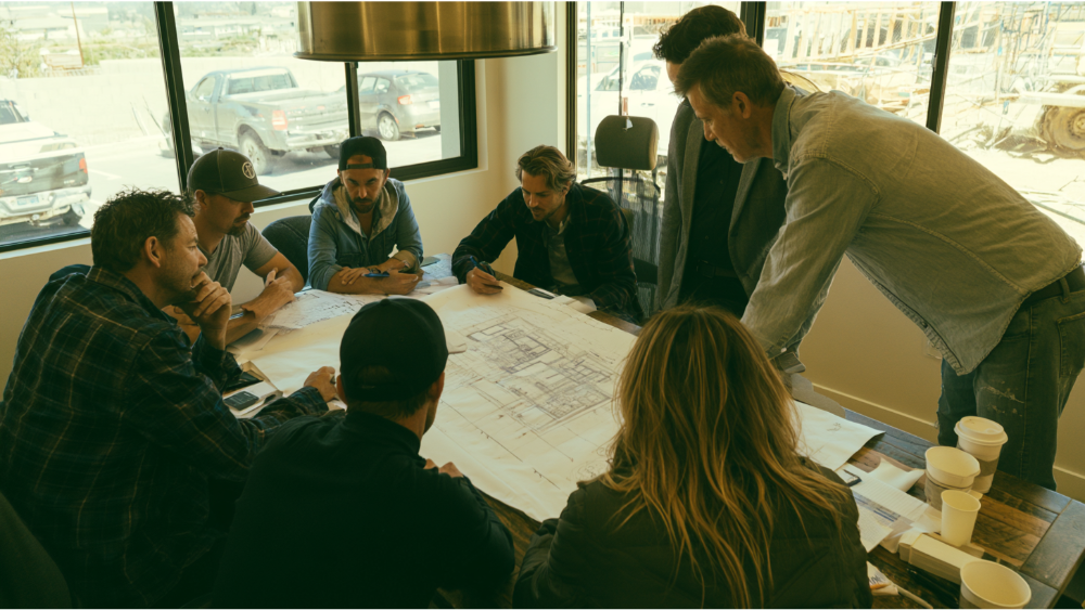 ADU design-build team coordinating architectural plans, engineering documents, permits, and construction activities.